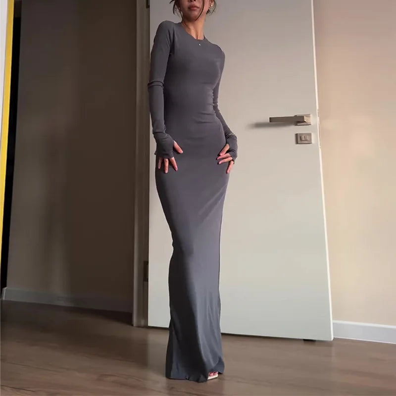 Elegant woman wearing a gray long-sleeve bodycon maxi dress on a city street – The Tottos