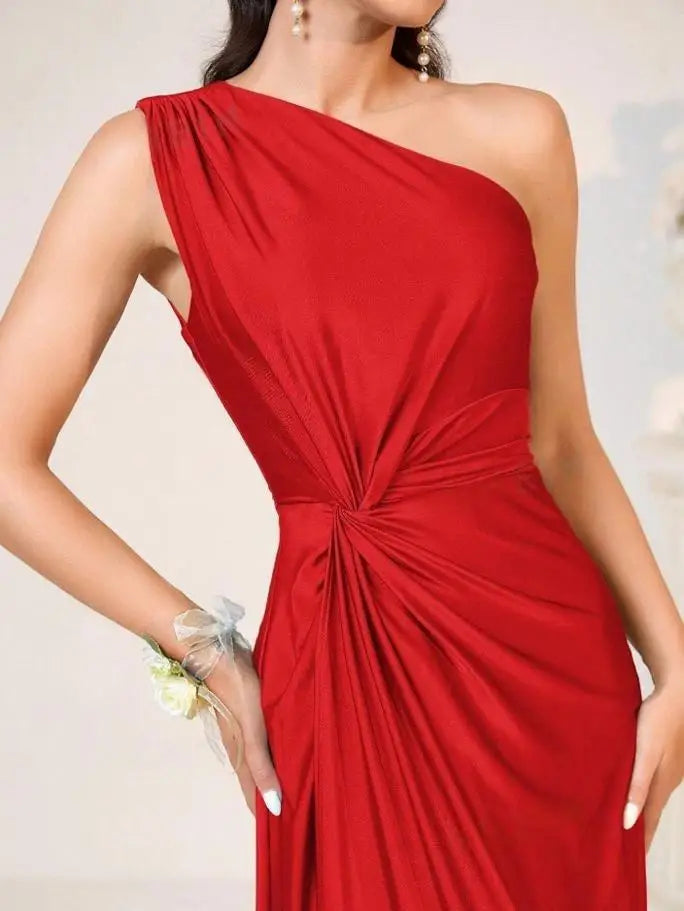 Red one-shoulder dress with a knot detail on a neutral background