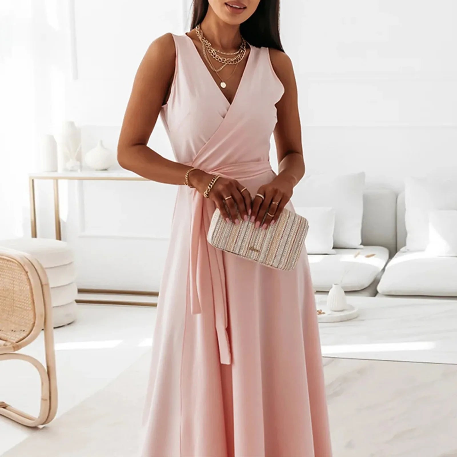Woman in a pink dress holding a clutch in a bright room