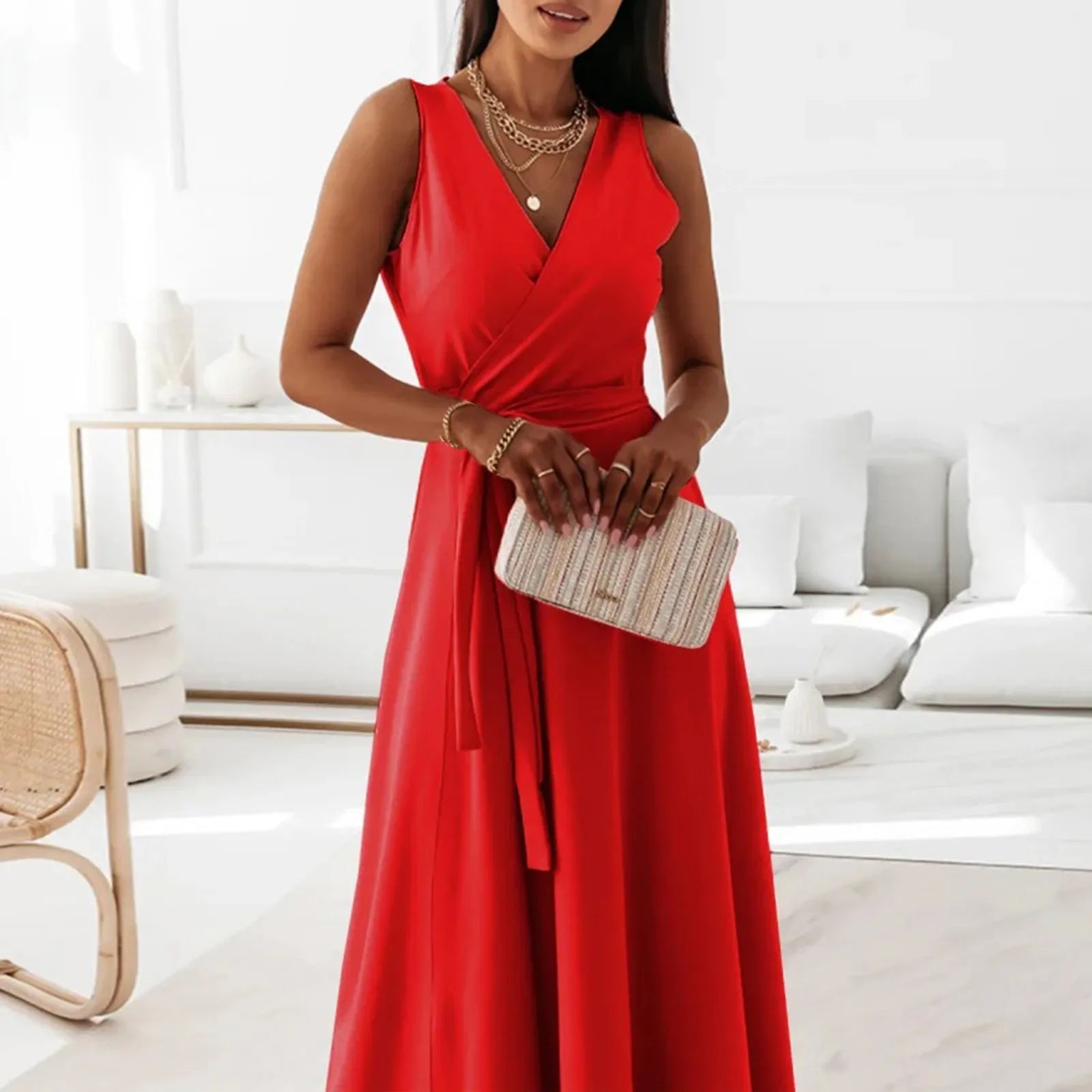 Woman in a red dress holding a clutch in a modern living room.