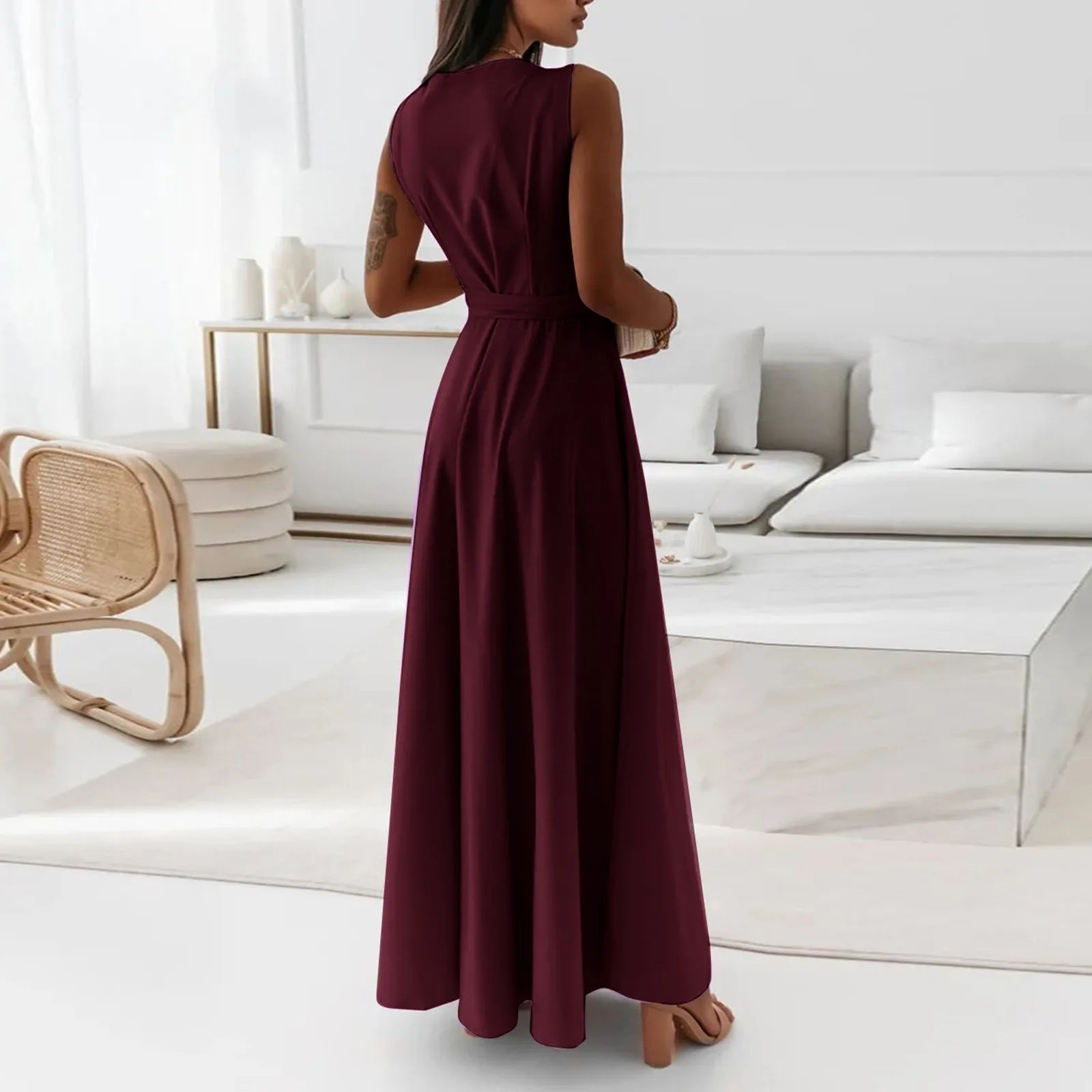 Elegant woman wearing a burgundy dress standing in a modern minimalist white room – The Tottos