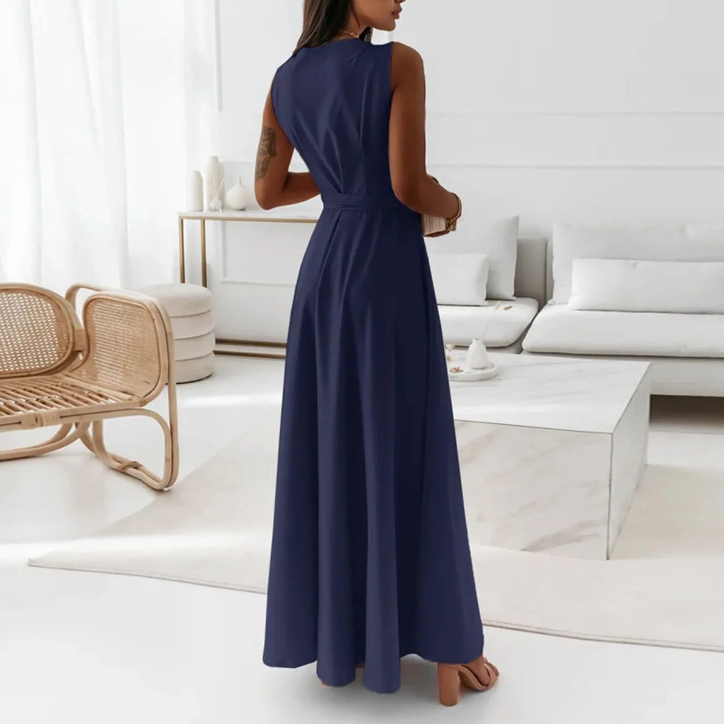 Elegant woman in a long navy dress standing in a modern white living room – The Tottos