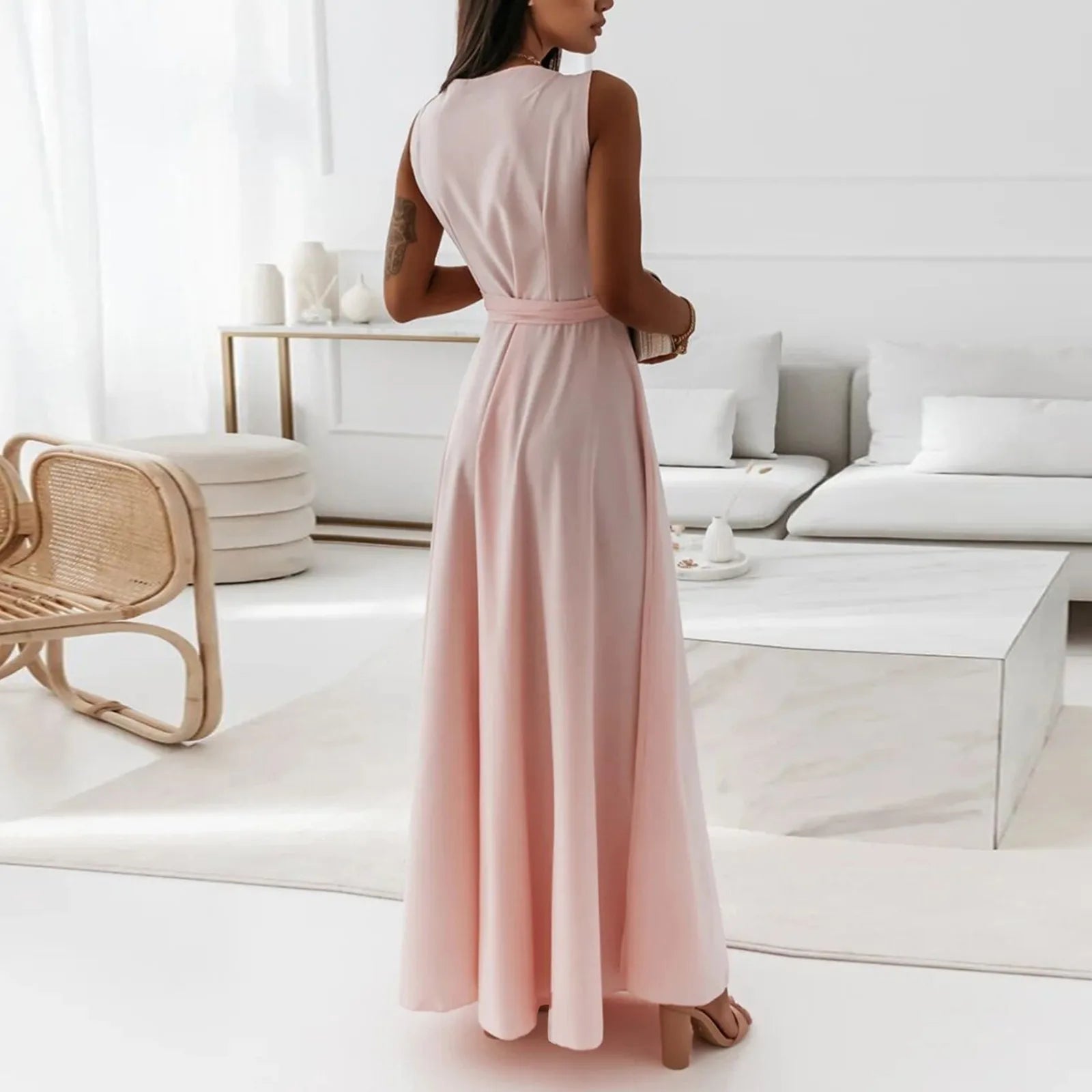 Elegant woman in a long pink dress standing in a modern living room – The Tottos