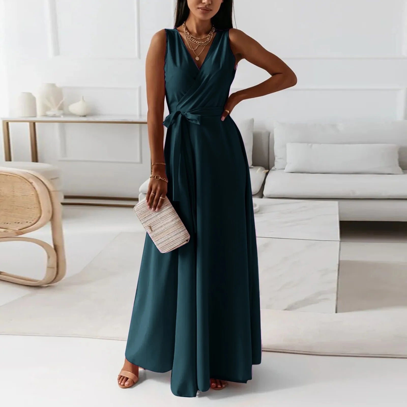 Elegant woman in a teal dress standing in a modern living room – The Tottos